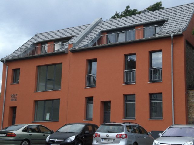Mehrfamilienhaus mit Fenstern und Balkontüren aus eigener Fertigung
